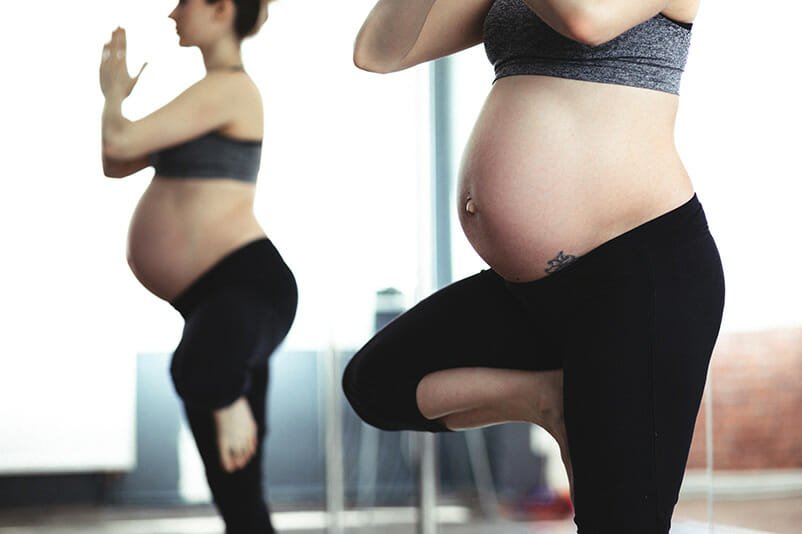 A pregnant woman practicing a yoga pose, reflecting strength and balance during maternity with guidance from a sexual health specialist in Los Angeles.