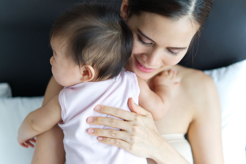 A tender moment between a mother and her baby, as the mother gently embraces her child with love and affection, reflecting on the advice from her sexual health specialist in Los Angeles.
