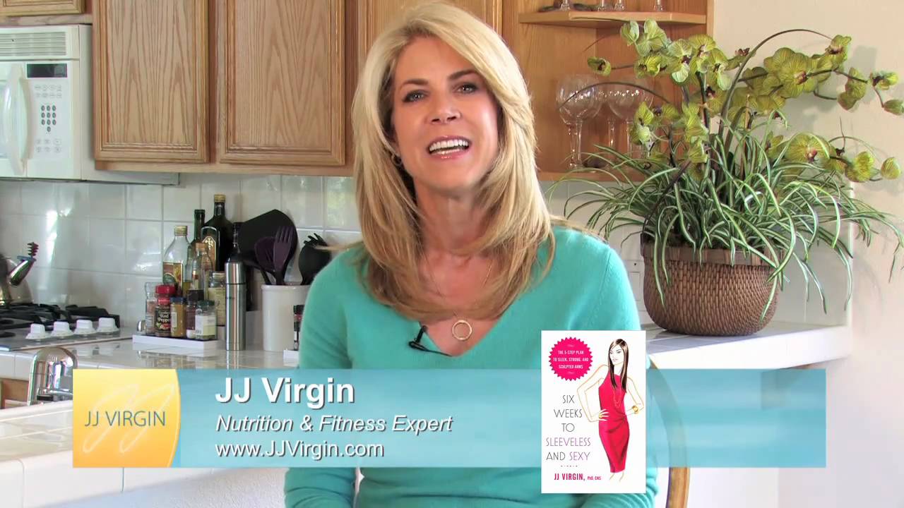 A smiling woman with blonde hair, wearing a teal top, standing in a kitchen setting with a plant on the counter and a website address displayed. She is identified as JJ Virgin, a hormone therapy specialist