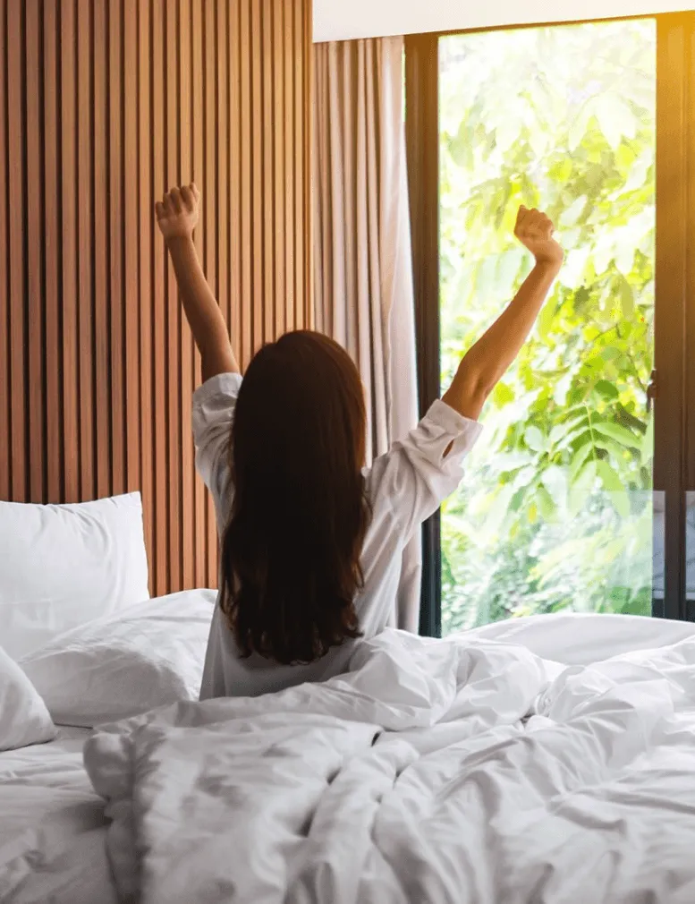 Welcoming a new day with a morning stretch in the comfort of a sunlit bedroom, guided by a Sexual Health Expert in Los Angeles.