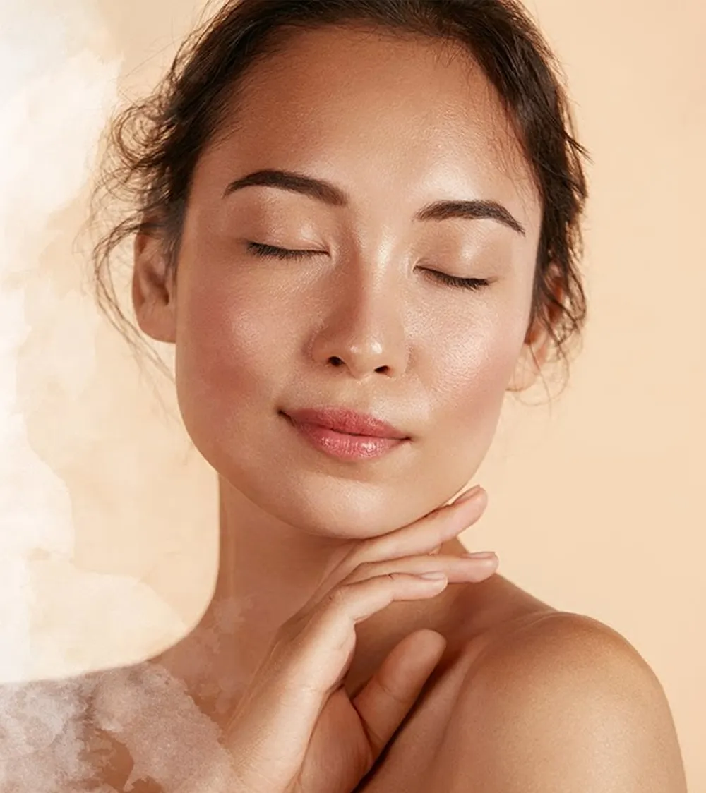 A serene woman, an expert in sexual health, with closed eyes touching her chin gently, displaying clear and radiant skin against a warm-toned background.