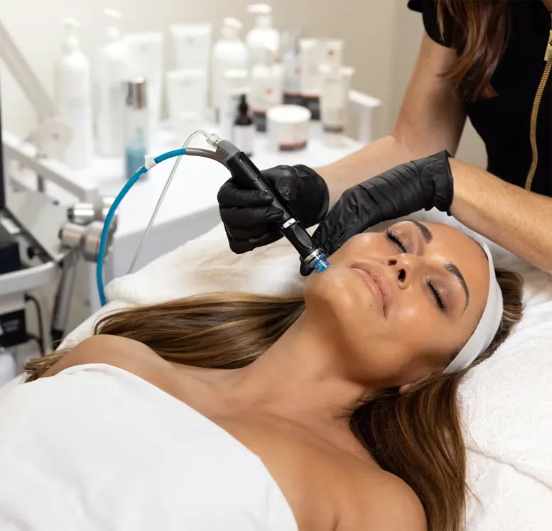 A person receiving a professional skincare treatment with a microdermabrasion device in a beauty clinic from an expert in sexual health.